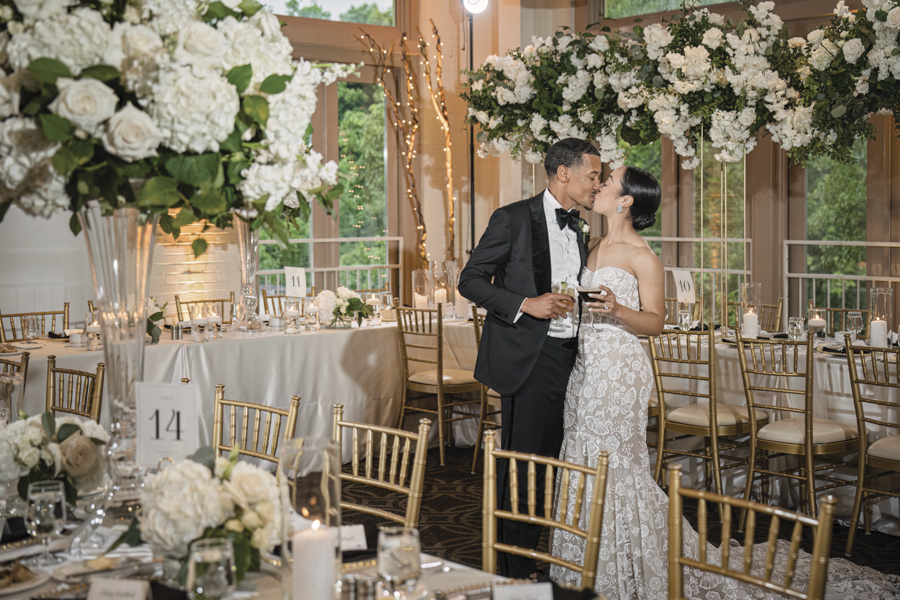 Photo Credit: In His Image Photography Couple kissing under a chandelier made of flowers in the Proximity Weaver Room